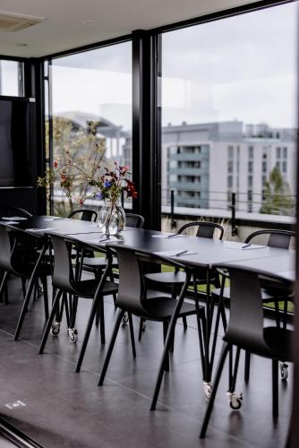 a table with chairs and a vase of flowers on it at THE FLAG München M. in Munich