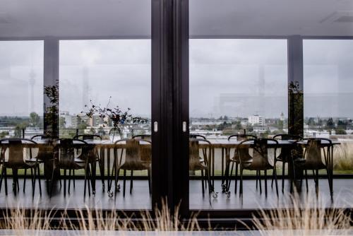 a dining room with a table and chairs and windows at THE FLAG München M. in Munich