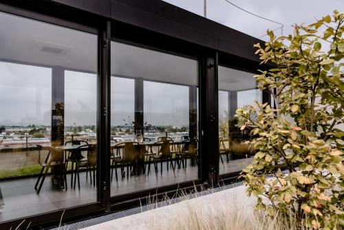 a dining room with glass windows and tables at THE FLAG München M. in Munich