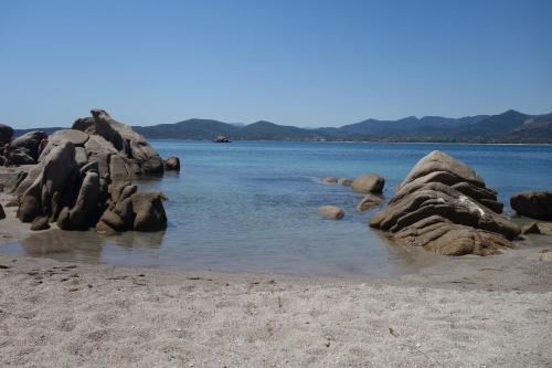 a group of rocks in the water on a beach at Capo Coda Cavallo, vacanze nella casa Il Maestrale in Capo Coda Cavallo