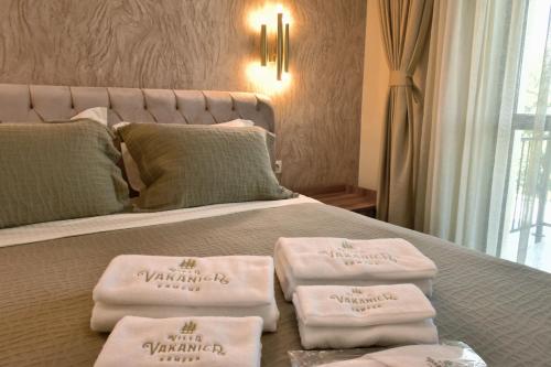 a bed with three towels sitting on top of it at Villa Vakanica in Petrich