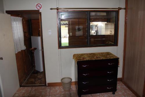 a bathroom with a dresser and a window and a door at Die Suidwester Gastehuis in Parys