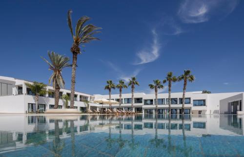a view of a resort with palm trees and a swimming pool at Paphos Hills Resort & Spa by Brown Hotels in Paphos