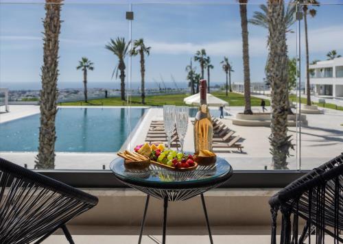 a bowl of fruit on a glass table next to a pool at Paphos Hills Resort & Spa by Brown Hotels in Paphos