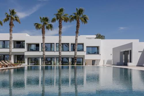 an image of a building with a swimming pool and palm trees at Paphos Hills Resort & Spa by Brown Hotels in Paphos
