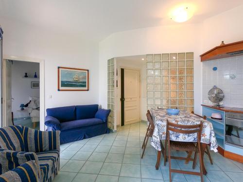 un salon avec une table et un canapé bleu dans l'établissement Le Marie Jeanne 6 Pers Giardino Vista Mare, à Villefranche-sur-Mer