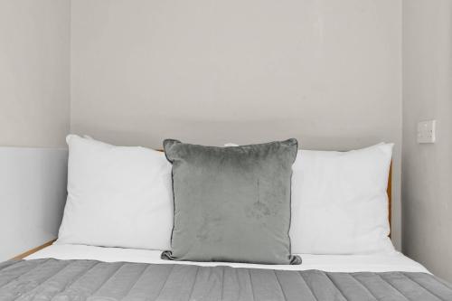 a bed with two white pillows and a gray pillow at Cleveland Residences Russell Square in London