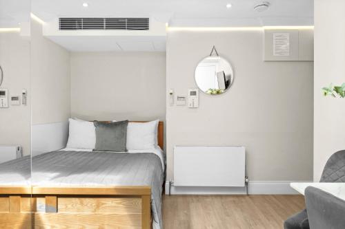 a small bedroom with a bed and a mirror at Cleveland Residences Russell Square in London
