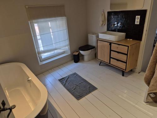 une salle de bain avec un lavabo, une baignoire et des toilettes dans l'établissement le clos de l'olivier, à Eyragues