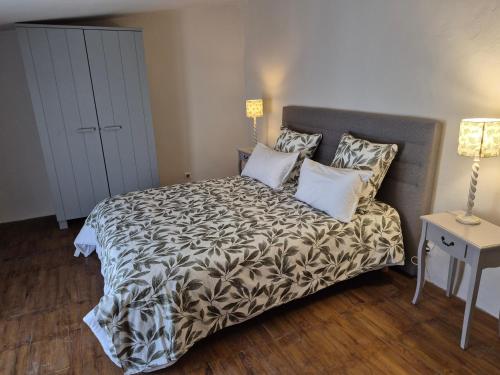 - une chambre avec un lit doté d'une tête de lit grise et d'oreillers dans l'établissement le clos de l'olivier, à Eyragues