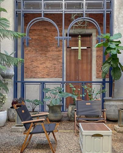 two chairs in front of a building with a door at Khunluang Hostel in Chiang Mai