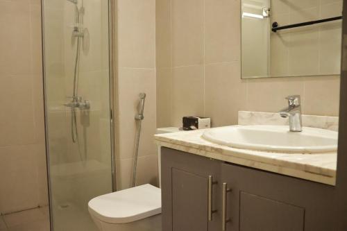 ein Badezimmer mit Toilette, Waschbecken und Dusche in der Unterkunft Jinnuo vacation home in Dubai