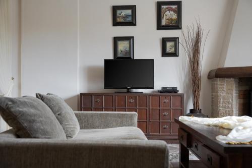 a living room with a couch and a tv at Villa Aurora Crete in Koxaré