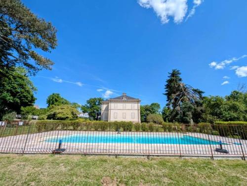 une grande piscine avec un bâtiment en arrière-plan dans l'établissement Les Croisettes, à Joncy