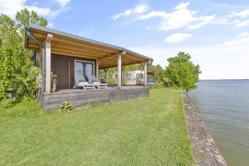 a house on the shore of a body of water at Delightful tiny river-view home in Šamorín