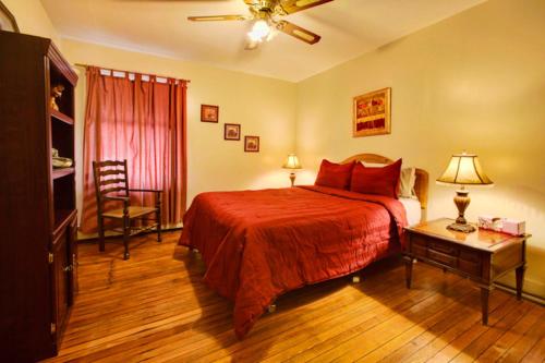 una camera con un letto con una coperta rossa e un tavolo di Suites on Main a Margaretville