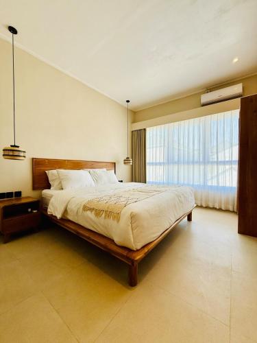a bedroom with a large bed and a large window at Cozy Living Kalos Villa in Kerobokan