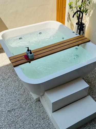 a bath tub with a wooden deck on top of it at Cozy Living Kalos Villa in Kerobokan