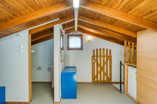 a room with a wooden ceiling and a blue refrigerator at Waves Melody in Kómi