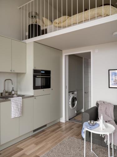 a kitchen and living room with a loft bed at Waterfront Cabins in Gothenburg