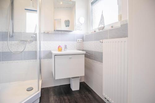 a white bathroom with a sink and a shower at "Haus Hinnerk 3" Haus Hinnerk 3, Bungalow in Büsum