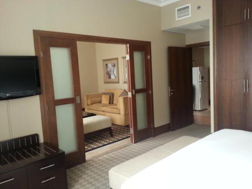 a room with a bedroom with a large mirror at Sheraton Khalidiya Hotel in Abu Dhabi