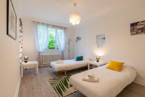 une petite chambre avec deux lits et une fenêtre dans l'établissement L'artiste, à Annecy