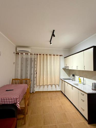 a kitchen with a table and a dining room at Kamberi Hotel & Apartments in Velipojë