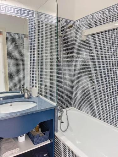 une salle de bain avec un lavabo, une baignoire et un miroir dans l'établissement Appartement cosy, à Talmont-Saint-Hilaire