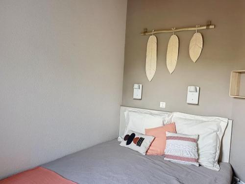 une chambre avec un lit avec des oreillers roses et blancs dans l'établissement Appartement cosy, à Talmont-Saint-Hilaire