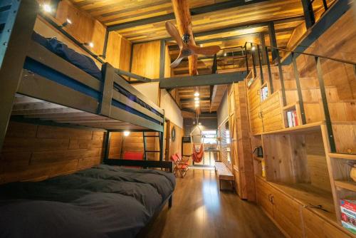 a bedroom with two bunk beds and wooden walls at SLEEPY MOUNTAIN in Karatsu