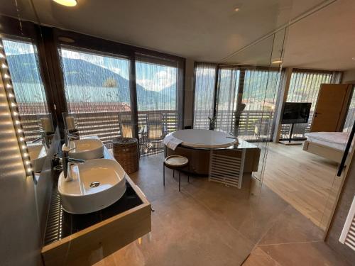 a bathroom with a sink and a tub with a view at Villa Erika in Tirolo
