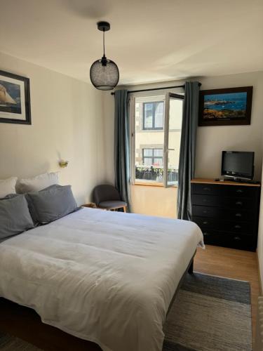 une chambre avec un grand lit et une fenêtre dans l'établissement Les 3 couronnes, à Granville