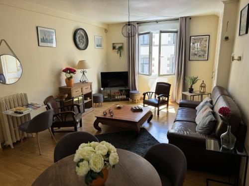 a living room with a couch and a table at Les 3 couronnes in Granville
