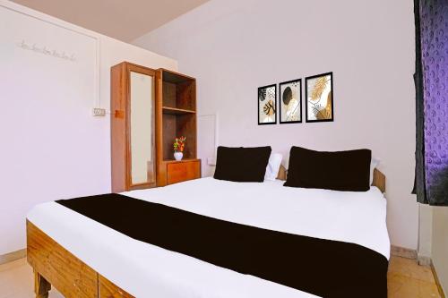 ナーシクにあるHotel O Paradiseのベッドルーム(白い大型ベッド、黒い枕付)