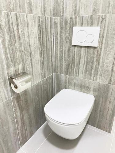 a bathroom with a white toilet and a sign on the wall at Rooms Miklošičeva in Ljubljana
