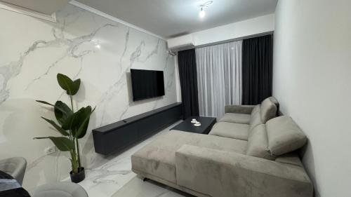a living room with a couch and a tv at Royal Apartments in Skopje