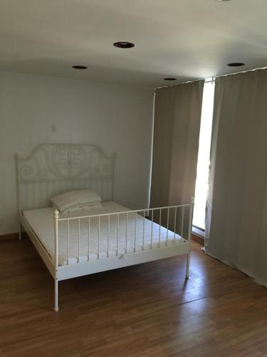 a white bed in a room with a window at Brooklyn Beach Location in Brooklyn