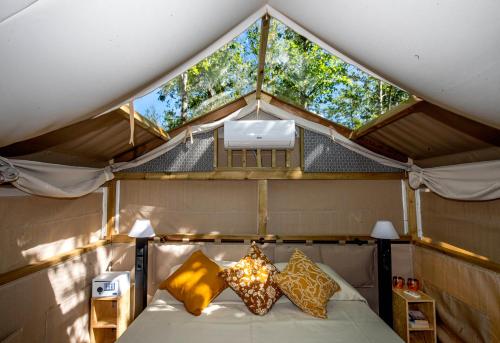 a bedroom in a dome with a bed and two windows at Camping Village Baia Azzurra in Castiglione della Pescaia