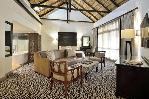 a living room with a couch and a table at Bakubung Bush Lodge in Ledig