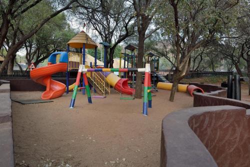 a playground in a park with colorful playground equipment at Bakubung Bush Lodge in Ledig