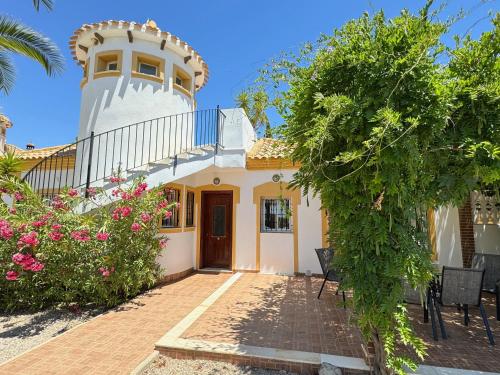 a house with a turret and a patio with flowers at Casa Maravilla in Mazarrón