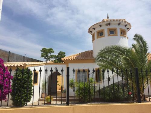 a house with a lighthouse behind a fence at Casa Maravilla in Mazarrón