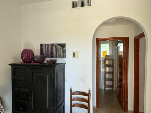 an archway leading into a room with a black dresser at Casa Maravilla in Mazarrón