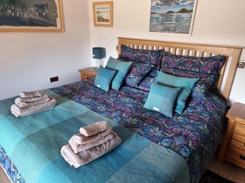 a bedroom with a bed with towels on it at The Weavers Cottage in Leurbost
