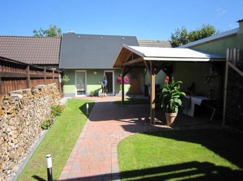 une maison avec un mur de pierre et un patio dans l'établissement Ferienhaus Malchow Mit Grill, Garten Und Terrasse, à Malchow