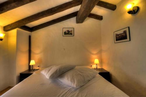 a bedroom with a white bed and two lamps at Stone House Kotli in Kotli