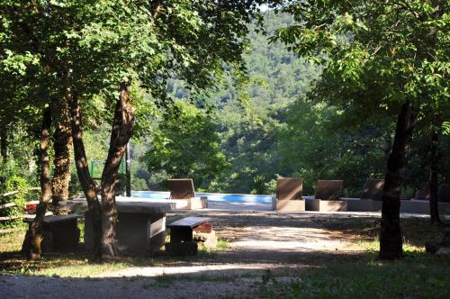 a group of benches in a park with trees at Stone House Kotli in Kotli