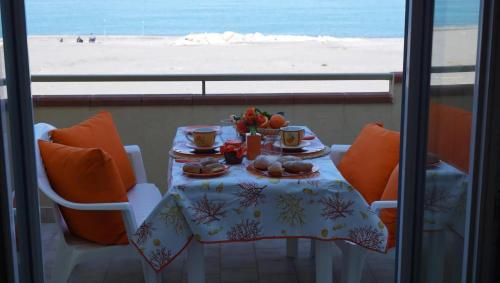 a table with food and a view of the beach at Terrazza Sul Mare in Terme Vigliatore