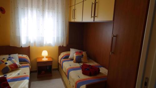 two beds in a small room with a red bag on them at Terrazza Sul Mare in Terme Vigliatore